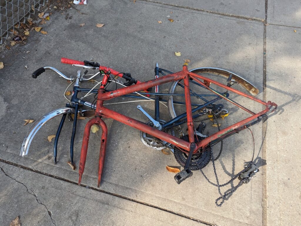 Broken bicycles abandoned on the sidewalk
